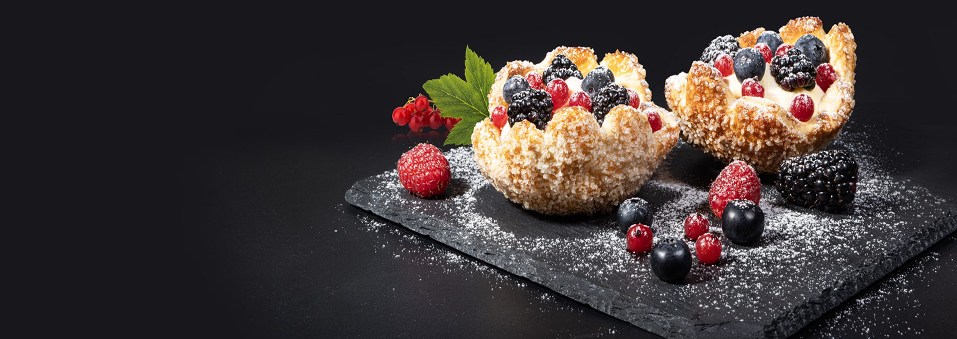 Piatto con 2 cestini monoporzione sfoglia frutti di bosco con decorazioni di more, mirtilli, lamponi, ribes e menta